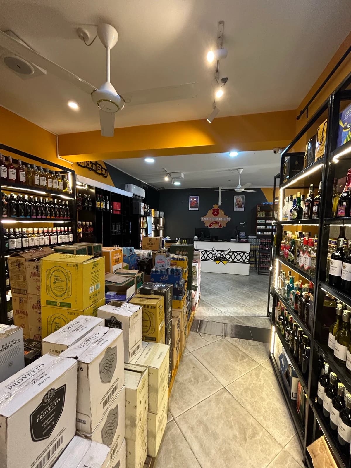 Inside the Zaks Premium store: lit shelves of wines and spirits, stacked cases and the front counter